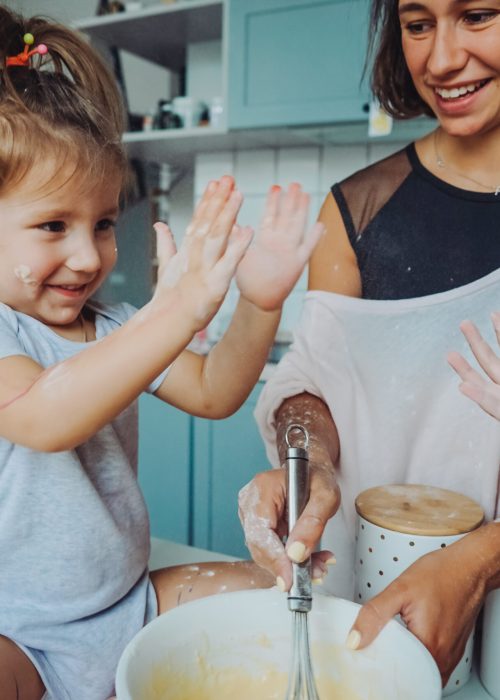 Mom and two daughters cook together in the kitchen